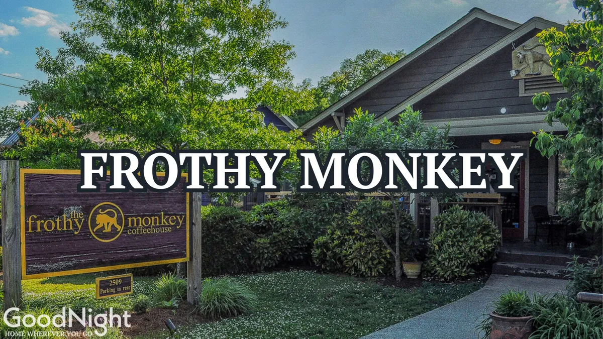 The welcoming exterior of Frothy Monkey, a popular local coffee shop with a charming wooden façade and a well-tended garden. The scene suggests a cozy spot for morning coffee, casual meetings, or remote work.