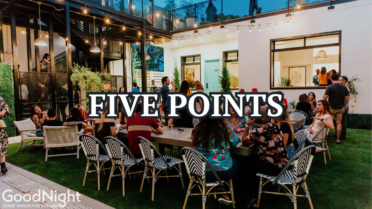 A lively outdoor seating area filled with people under string lights, with modern architecture in the background. The festive scene captures a sense of celebration, dining, and socializing typical of Nashville’s energetic group experiences.